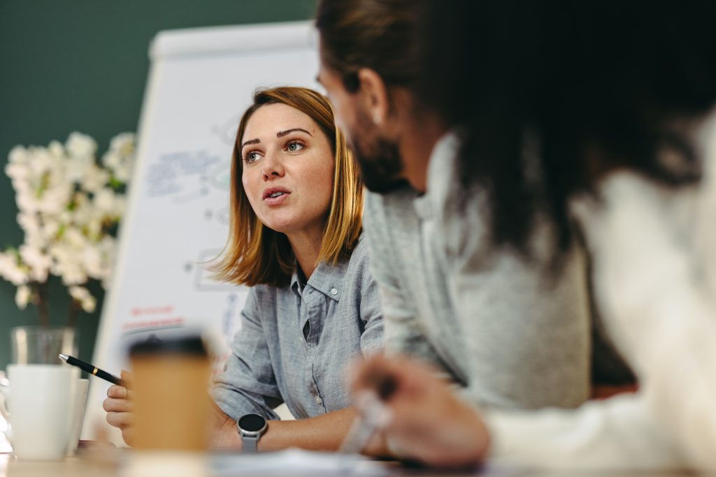 Young businesswoman having a discussion with her colleagues in a meeting Repairing Balance voor Organisaties