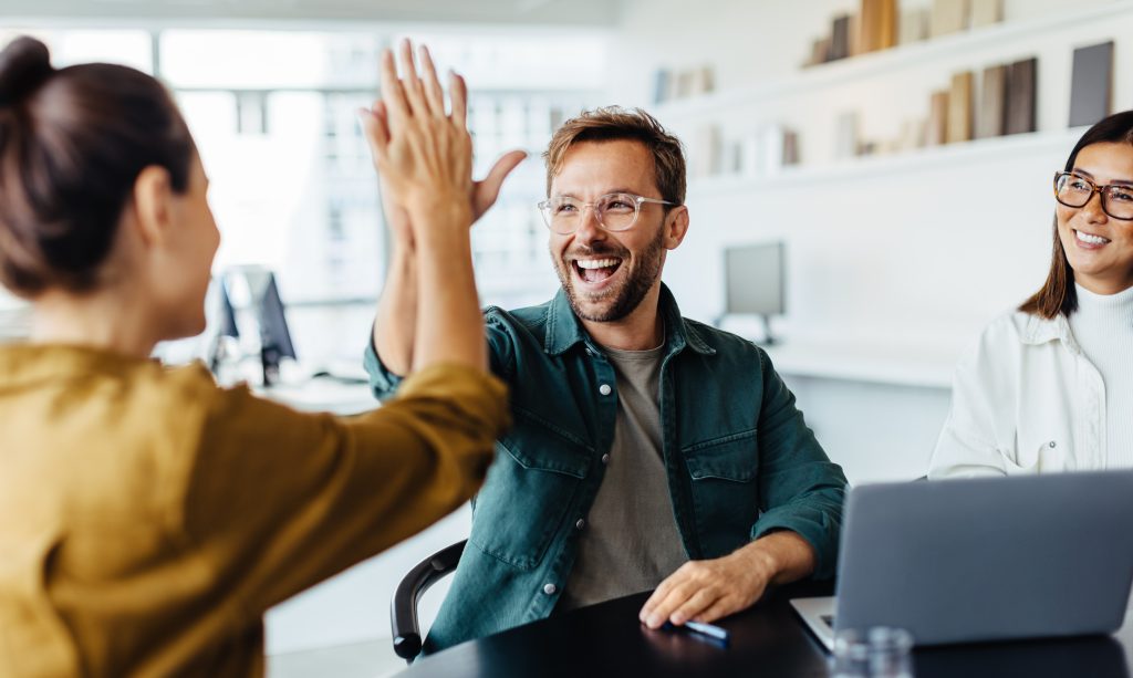 Business people celebrating success in an office Repairing Balance voor Organisaties