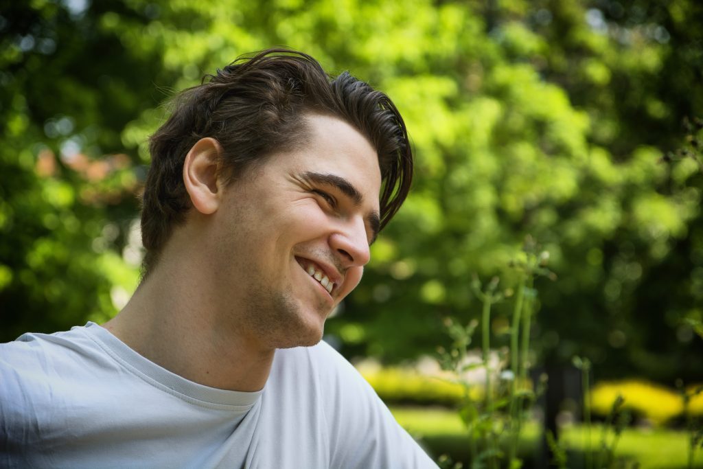 Attractive young man smiling in nature environment Testing Balance